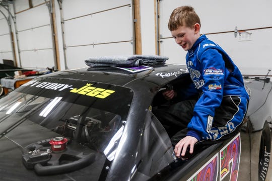Keegan Sobilo, 12, gets into his late model race car in the garage of his home in February in New Baltimore.