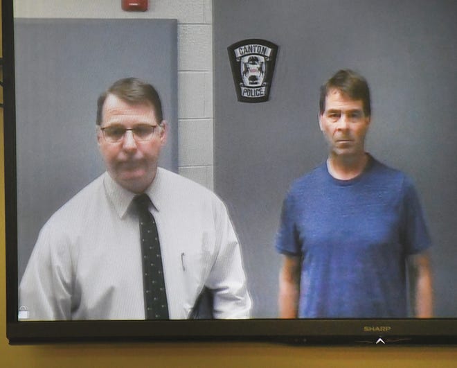 Van Buren police department detective Lt. Charles Bazzy, left, stands with 34th District Court Judge David Parrott, who is charged with alleged assault, during a video arraignment at the 35th District Court in Plymouth, Michigan on February 10, 2020.