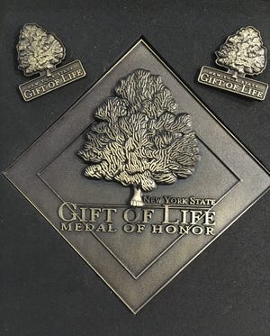 The Finger Lakes Donor Recovery Network sent Lars and Marcy Luffman a Gift of Life donor medal and two lapel pins in honor of their daughter, Abbey, who died on Jan. 12 after a sudden and brief battle with Idiopathic Thrombocytopenic Purpura.