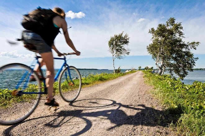 Going like the wind: A cyclist speeds north on the Island Causeway in Lake Champlain on Aug. 20, 2010. Her trajectory leads her to a small bike ferry and on to South Hero Island.