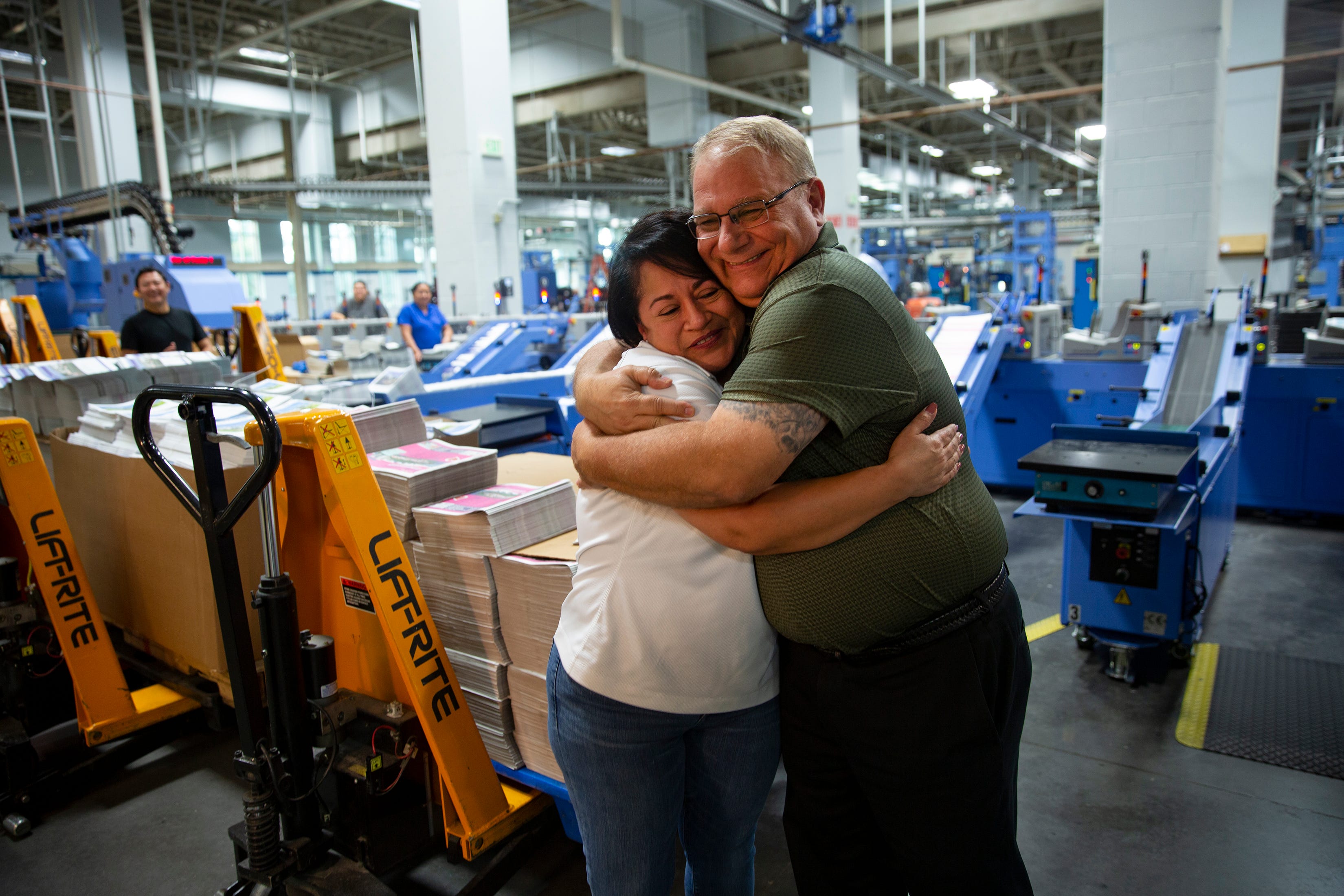 Naples Daily News Associate Mailroom Manager Gloria Taylor receives a hug from Operations Manager Jim Zajas,  Thursday, Feb. 6, 2020, at the Naples Daily News building in North Naples.