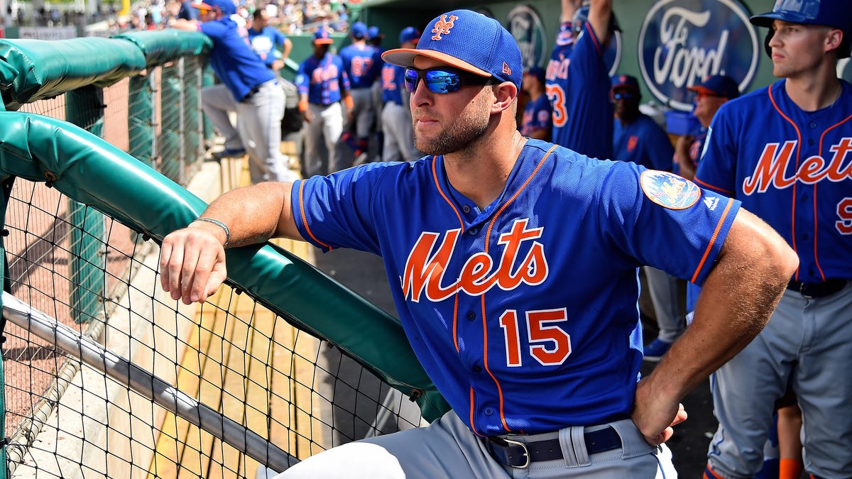 New York Mets left fielder Tim Tebow (15) looks on from the dugout priror to the spring training game against the Boston Red Sox at JetBlue Park.