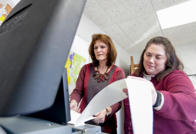 Karen Simons, left, and Dawn Novak submit ballots into the machine during poll testing for spring elections Wednesday, Feb. 12, 2020, in Allouez, Wis.