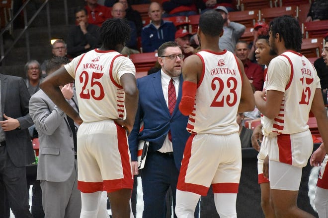 SUU seniors Cam Oluyitan and Dwayne Morgan chat with coach Todd Simon during a game this season. Oluyitan and Morgan were standout players on this year's SUU team, both on and off the court.