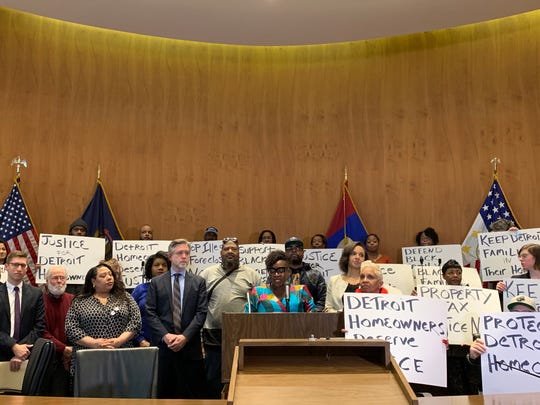 Bernadette Atuahene, a professor at the Chicago-Kent College of Law, Center, speaks at a press conference on February 13, 2020 at the Coleman A. Young Municipal Center where housing rights activists and elected officials announced a federal class action lawsuit against the city of Detroit for belatedly Property tax notices in 2017. The lawsuit is one of several appeals brought in the post-Great Recession years for the city's inflated property tax bills.
