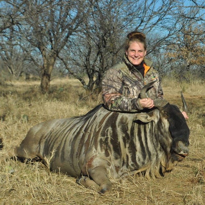 Wisconsin hunter and spice mix business owner Starla Batzko specializes in cooking her own wild game. Here she poses with a wildebeest she hunted.