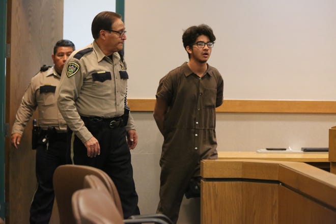 Josiah Segura, of Las Cruces, is led into Judge Conrad Perea's Third Judicial District Courtroom for a bond reduction hearing Thursday, Feb. 13, 2020. Segura is being tried as an adult for allegedly using a firearm to rob another teen of 20 grams of prescribed medical marijuana and cash.
