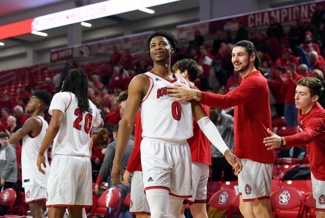 Stanley Umude of USD smiles as he walks back to his teammates after beating Western Illinois on Wednesday, Feb. 12, at the Sanford Coyote Sports Center in Vermillion.