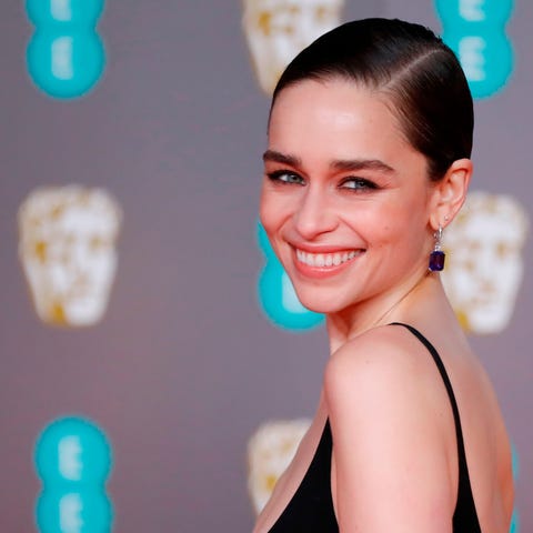 British actress Emilia Clarke poses on the red car