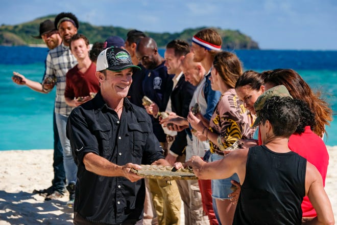 "Survivor" host Jeff Probst, left front, hands 20 'Winners at War' competitors information that will reveal which team they will be on during Wednesday's premiere of the first all-champions edition.
