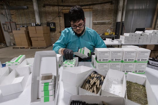 A worker packages hemp cigarettes at Vance Global.