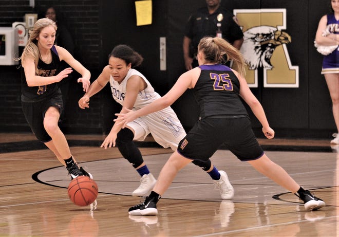 Cooper's Kyla Speights, center, dribbles the ball between Wylie's Morgan Travis, left, and Makinlee Bacon in the second half. Cooper beat the Lady Bulldogs 46-42 in the District 4-5A seeding game for the No. 3 seed Friday, Feb. 14, 2020, at Abilene High's Eagle Gym.