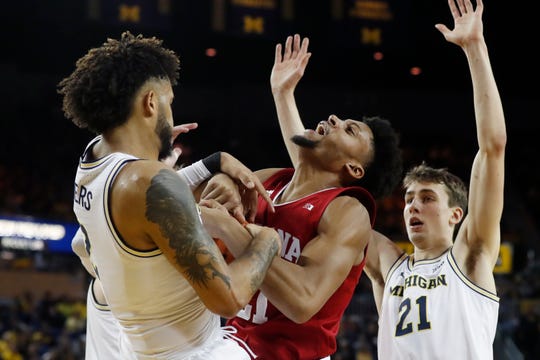 Indiana forward Jerome Hunter, center, and Michigan forward Isaiah Livers, left, fight for the rebound during the first half Sunday in Ann Arbor.