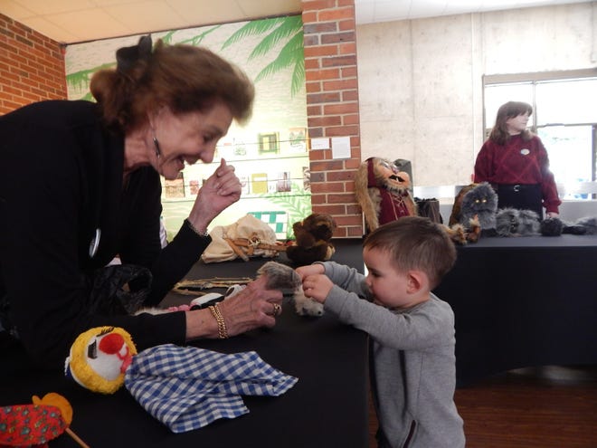 Jan Kaufman demonstrates to a curious boy the workings of the finger puppet.