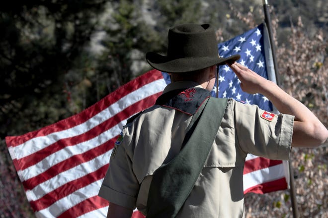 In this Sunday, Nov. 11, 2018 file photo, Boy Scouts lead the Pledge of Allegiance to begin a Veterans Day ceremony in Wrightwood, Calif. Facing a possible bankruptcy due to sex-abuse litigation, the Boy Scouts of America issued a new apology Tuesday, Feb. 11, 2020, to survivors of abuse and announced plans for expanded services to support them.