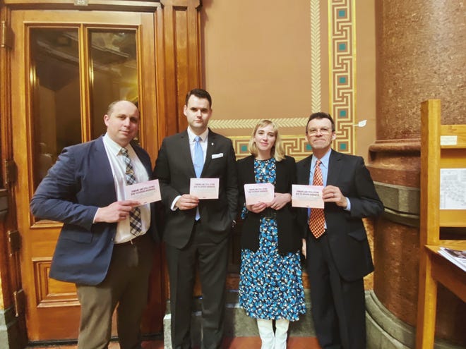 Dr. Daniel Runde, Sen. Zach Wahls, IHRC Executive Director Sarah Ziegenhorn and Sen. Joe Bolkcom at the Iowa State Capitol Feb. 11, 2020, in Des Moines. The cards they hold read, "Iowans are still dying due to opioid overdose."