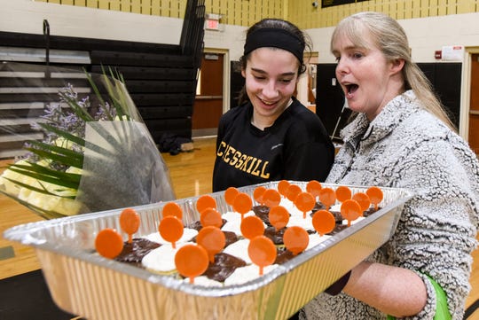 Cresskill High School plays Waldwick in girls basketball in Cresskill on Tuesday February 18, 2020. (From left) Cresskill #33 Colleen McQuillen is surprised by Patty Mioli and cupcakes after she beats the school record for most points.