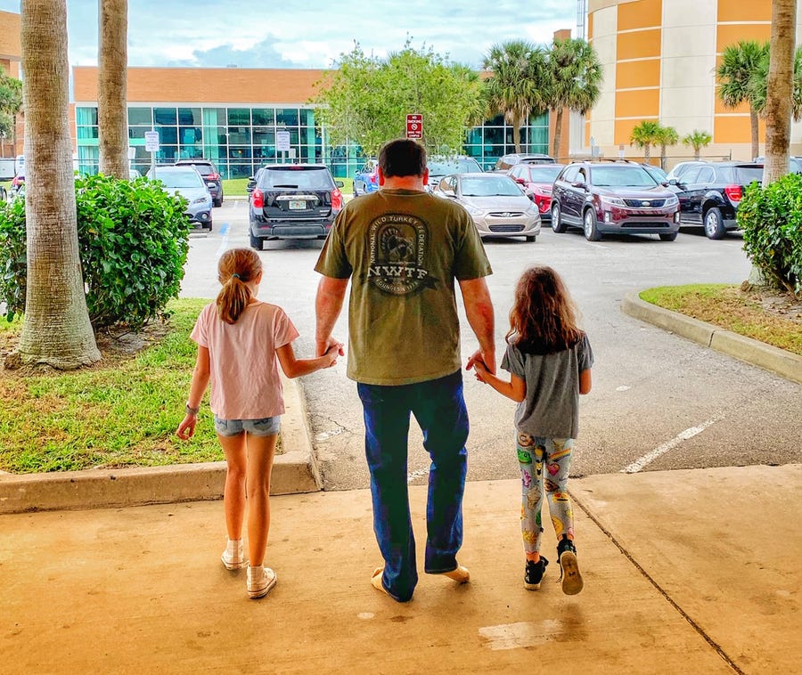 NASCAR driver Ryan Newman walks out of the hospital on Feb. 19 with daughters Brooklyn Sage, left, and Ashlyn Olivia, following a grisly wreck at the Daytona 500.