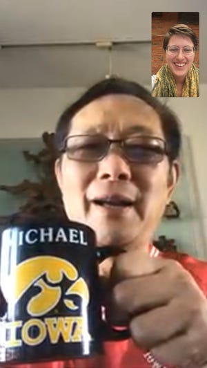 Michael Lee, owner of Hamburg Inn, holds up his University of Iowa mug during a FaceTime call with Iowa City Press-Citizen reporter Aimee Breaux. Lee has been in voluntary quarantine at his Shanghai home for more than 20 days.