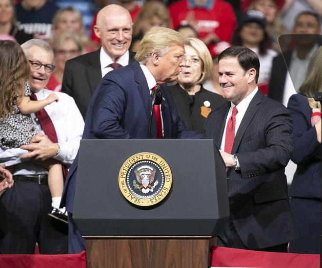 President Donald Trump greets Arizona Governor Doug Ducey (third from right) during a rally  at the Arizona Veterans Memorial Coliseum in Phoenix on Feb. 19, 2020.