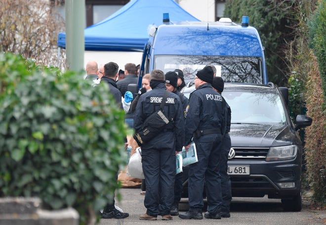 Police officers stand by the house where the suspected perpetrator was found dead after a series of deadly shootings in Hanau, Germany, Thursday Feb. 20, 2020. Several people were killed and others injured when shots were fired in Hanau late Wednesday, with the suspect and another person found dead at his home afterwards.