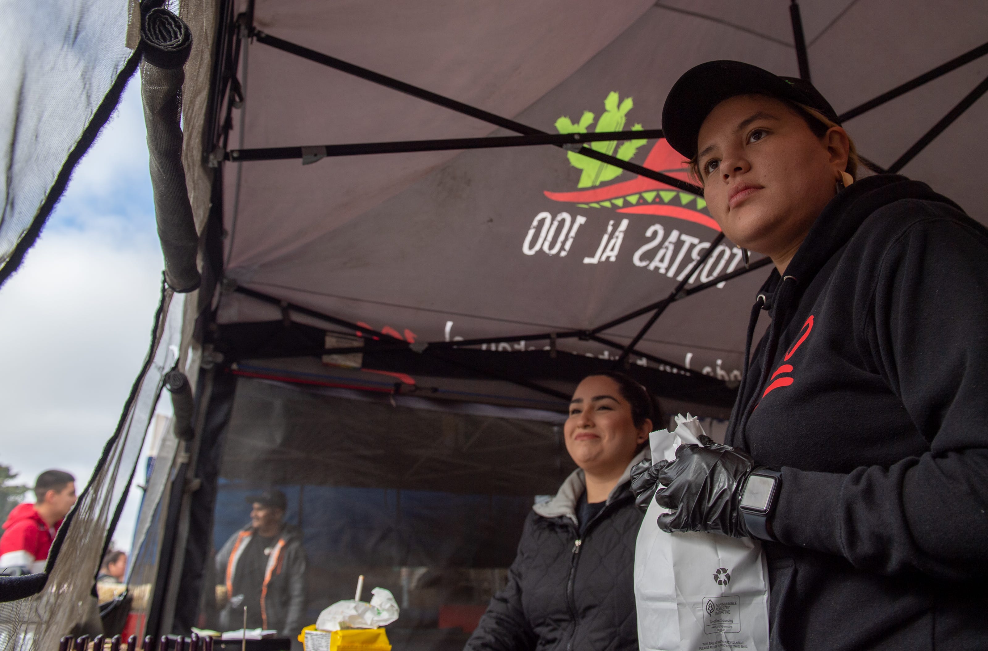 Diane Haro, izquierda, y Herminia Cervantes esperan a que los clientes de Tortas Al 100 retiren sus órdenes el 8 de febrero del 2020.