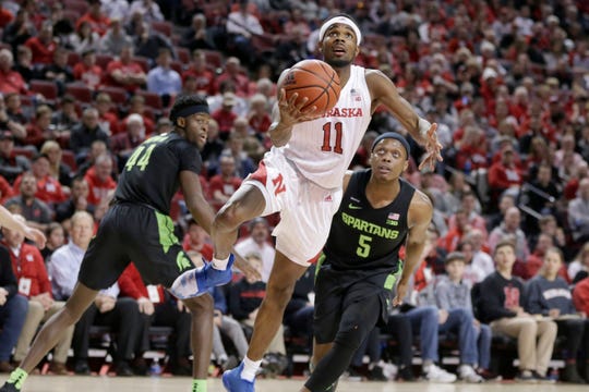 Nebraska's Dachon Burke Jr. (11) goes to the basket between Michigan State's Gabe Brown (44) and Cassius Winston (5).