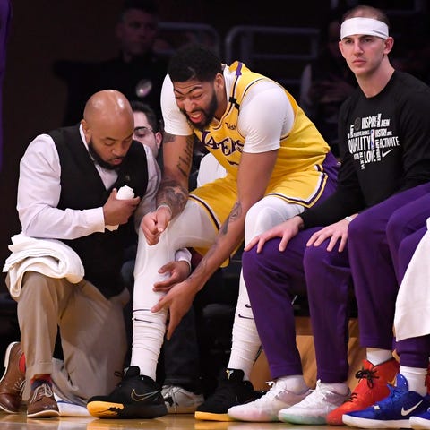 Anthony Davis grimaces as he examined by a trainer