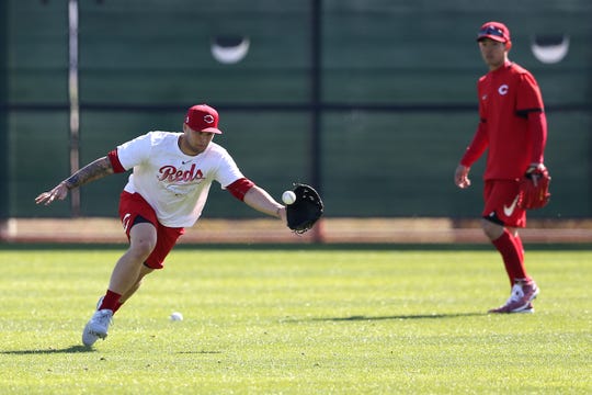 Cincinnati Reds center fielder Nick Senzel (15) catches a ball during outfield drills, Friday, Feb. 14, 2020, at the Cincinnati Reds Spring Training Facility in Goodyear, Arizona. 