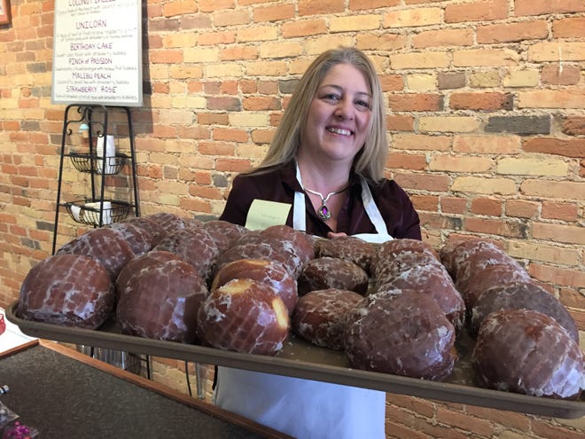 Chocolate Boutique and Bakery owner Teresa Chalifour holds a tray of paczki at her shop, Monday, Feb. 24, 2020.
