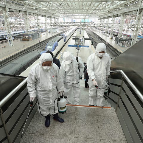 Workers wearing protective gears spray disinfectan