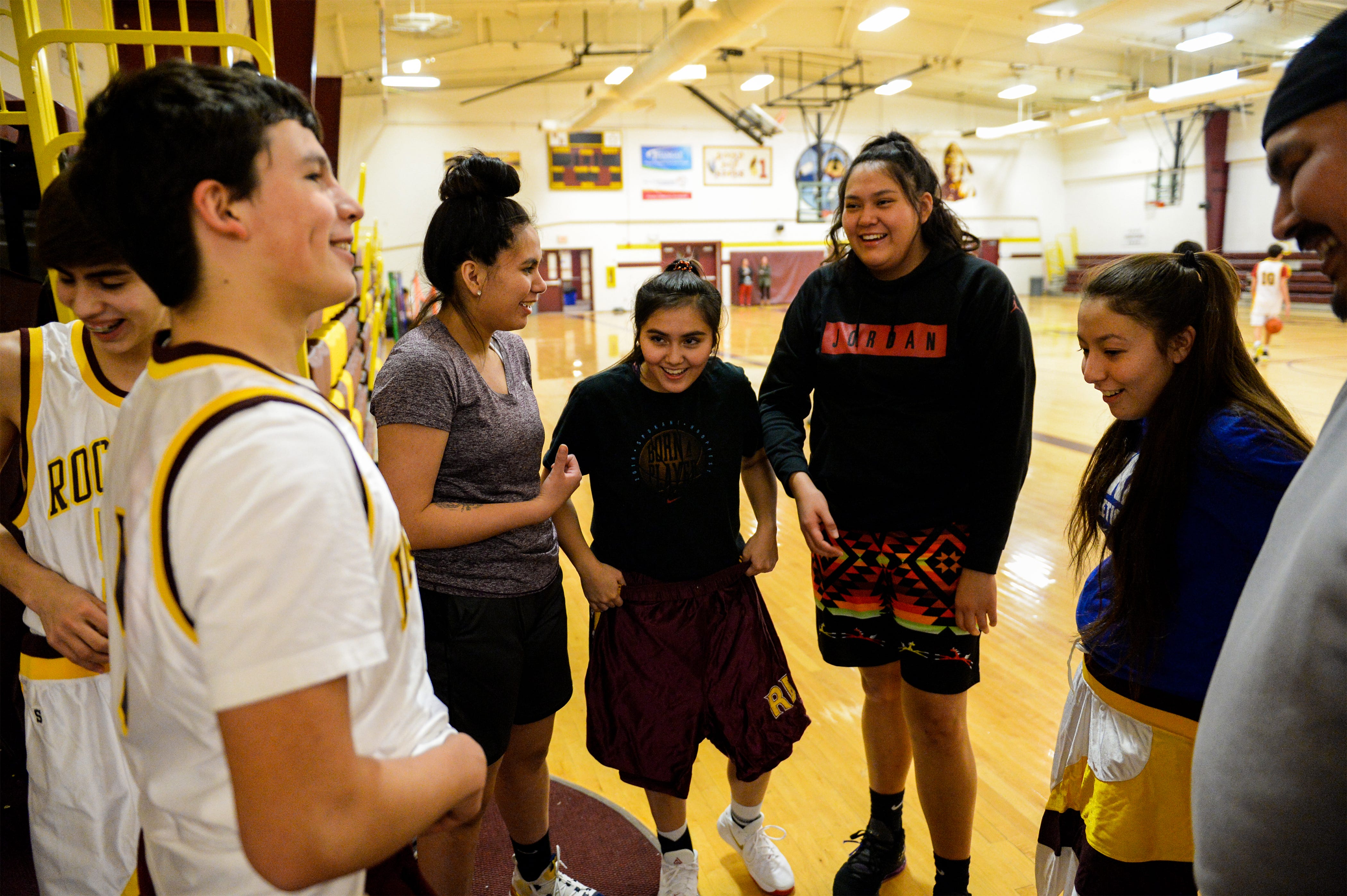 Members of the Rocky Boy girls and boys basketball teams try on old uniforms in between practices, Tuesday, February 25, 2020.