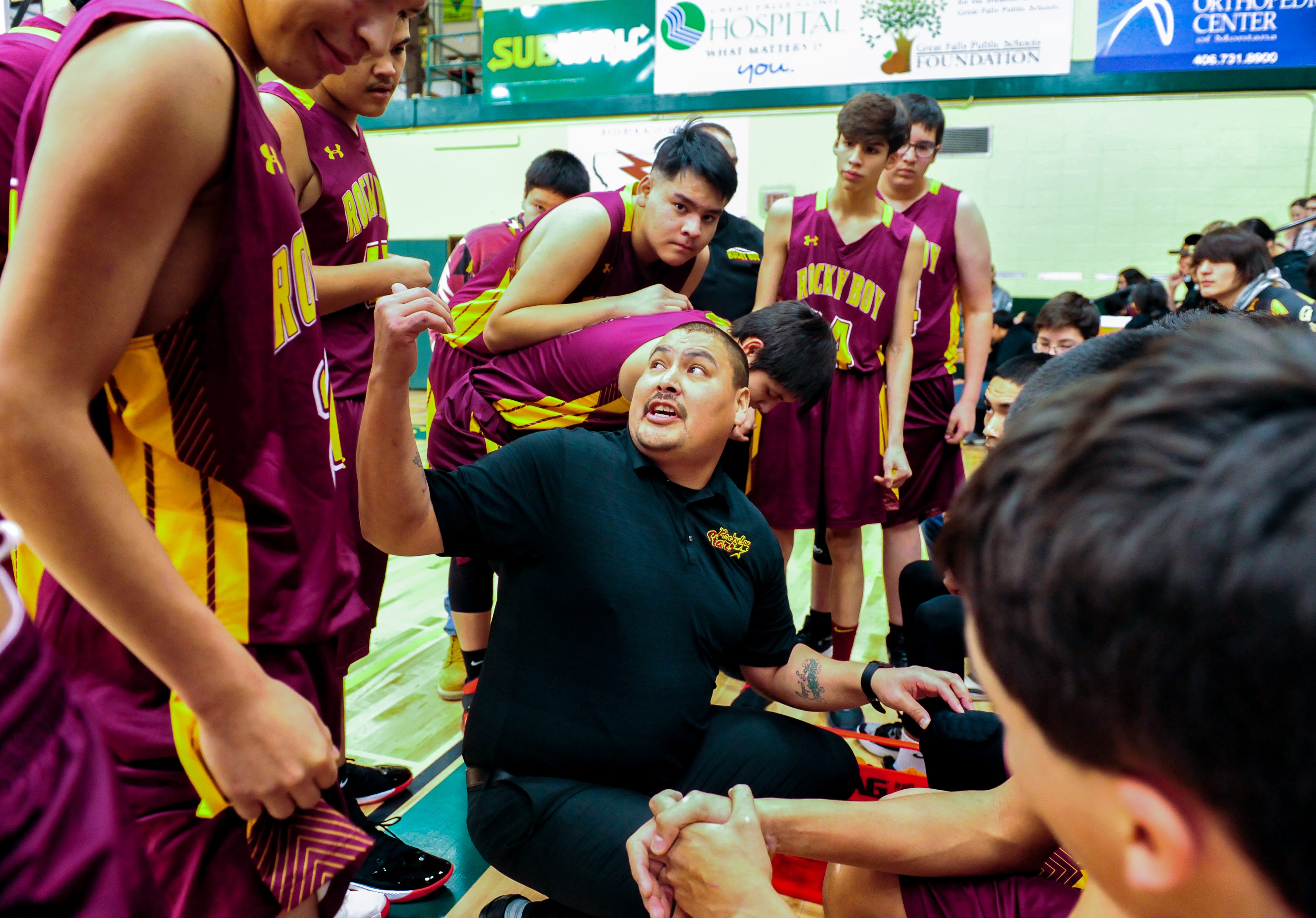 Adam Demontiney, Rocky Boy boys' basketball head coach, huddles with his team during a timeout in a game at the 2019 Native American Basketball Classic tournament at C.M. Russell High School in December.
