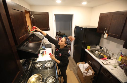 Barbara Rivera, Rochester, unpacks her kitchen as she moves back into the Apartments at Thurston Village at 447 Thurston Road in Rochester Wednesday, Feb. 26, 2020.