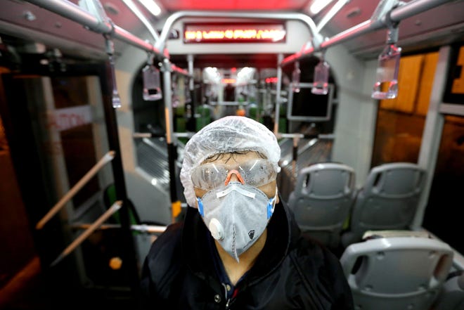 An employee of the Tehran municipality cleans a bus to prevent the spread of the COVID-19 disease on February 26 in Iran.