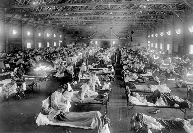 Influenza victims crowd into an emergency hospital near Fort Riley, Kansas, in this 1918 file photo. The 1918 Spanish flu pandemic killed at least 20 million people worldwide. (AP Photo/National Museum of Health)