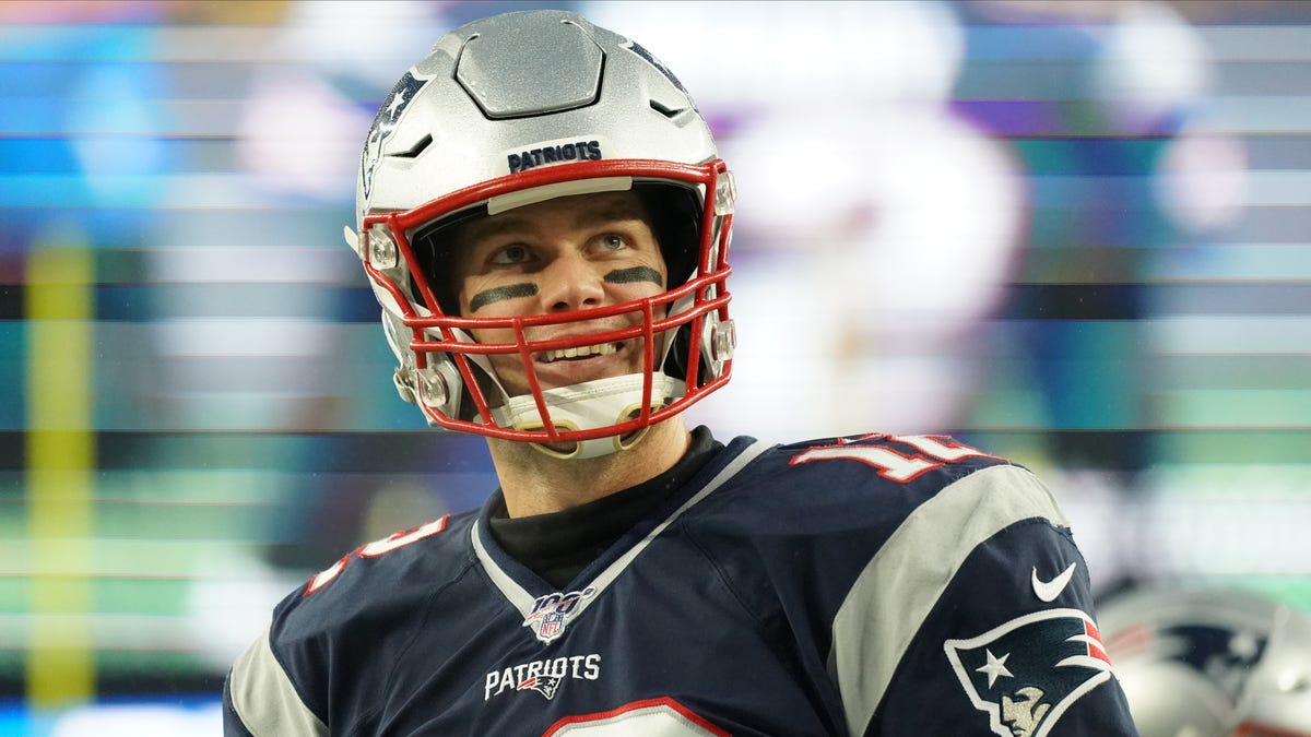 New England Patriots quarterback Tom Brady (12) reacts to fans during warm up before the start of the game against the Dallas Cowboys at Gillette Stadium.