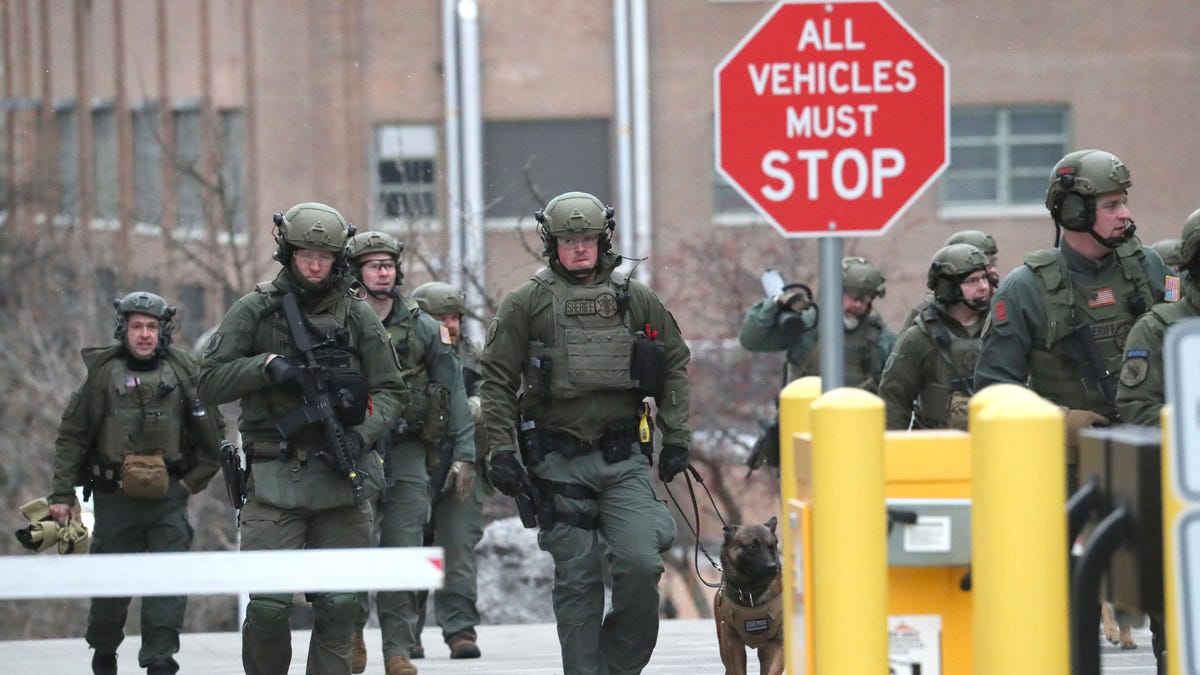 Feb 26, 2020; Milwaukee, WI, USA;  Several Police agency tactical teams working together as a group sweep the grounds and enter a parking structure across the street from corporate offices, checking each vehicle.