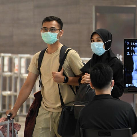 A couple, wearing protective facemasks amid fears 