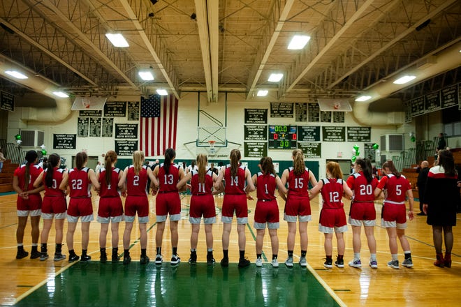 The teams listen to the national anthem during the girls basketball game between the Champlain Valley Union Redhawks and the Rice Green Knights at Rice Memorial High School on Thursday night February 27, 2020 in South Burlington, Vermont.