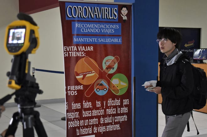 Una pancarta informativa sobre coronavirus puede verse en un aeropuerto.