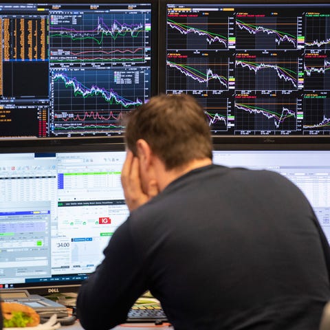 A broker watches his screens with the German stock