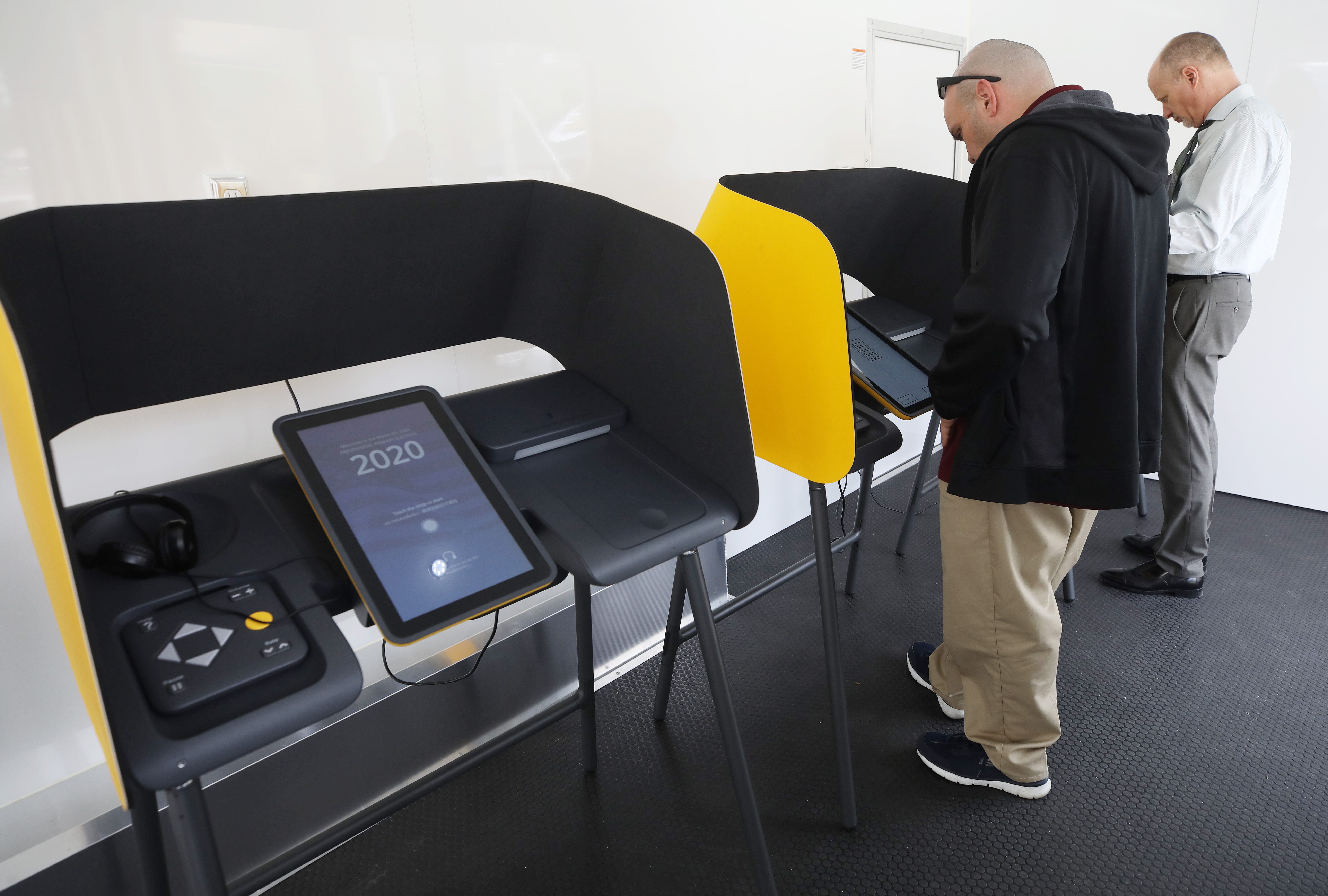 Voters prepare their ballots in voting booths during early voting for the California presidential primary election at a new L.A. County Mobile Vote Center