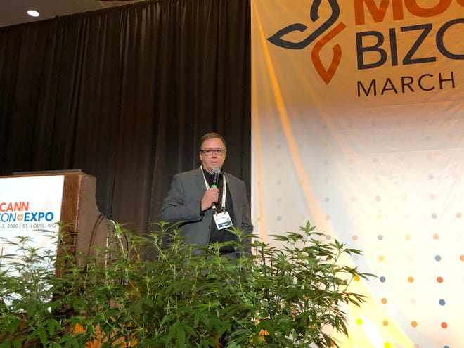 Flanked by hemp plants, Lyndall Fraker, director of Missouri's medical cannabis program, gives a keynote speech at MoCannBizCon+Expo in St. Louis on Monday, March 2, 2020.