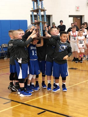 The Zanesville fourth grade team holds up the trophy for winning the state championship for their division at the 2020 Ohio Youth Basketball Division II State Championship in Columbus.