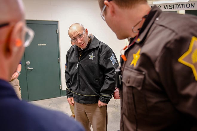 Fellow officers watch as the restraining kevlar cord is unwrapped from Lt. Matt Corn with the Vanderburgh County Sheriff’s Department as representatives from BolaWrap demonstrate their BolaWrap 100 hand-held restraint device for law enforcement officials at the Vanderburgh County Sheriff’s Office Wednesday, March 4, 2020.