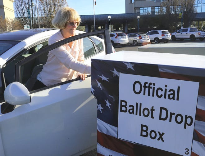Judy Champagne puts her mail-in ballot in the drop box outside Redding City Hall on Tuesday, March 3, 2020, for the presidential primary election.
