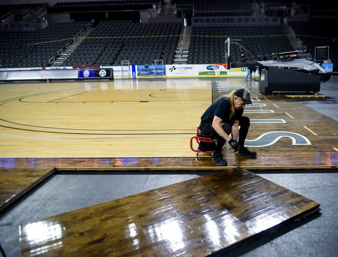 Crews install the basketball court in preparation for the Summit League tournament on Wednesday, March 4, 2020 at the Denny Sanford Premier Center. 