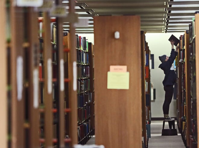 Isabella Pipp, a senior majoring in anthropology, grabs a book in the Golda Meir Library at the University of Wisconsin-Milwaukee.