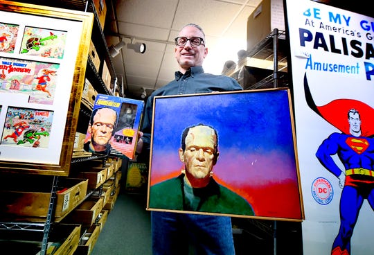 Hake's Auctions Production Manager Todd Sheffer shows original artwork in the auction room at the Springettsbury Township business, which was used on the figure's retail boxes, left, Thursday, March 5, 2020. The company is hosting an online and phone bidding auction March 11 and 12. Bill Kalina photo